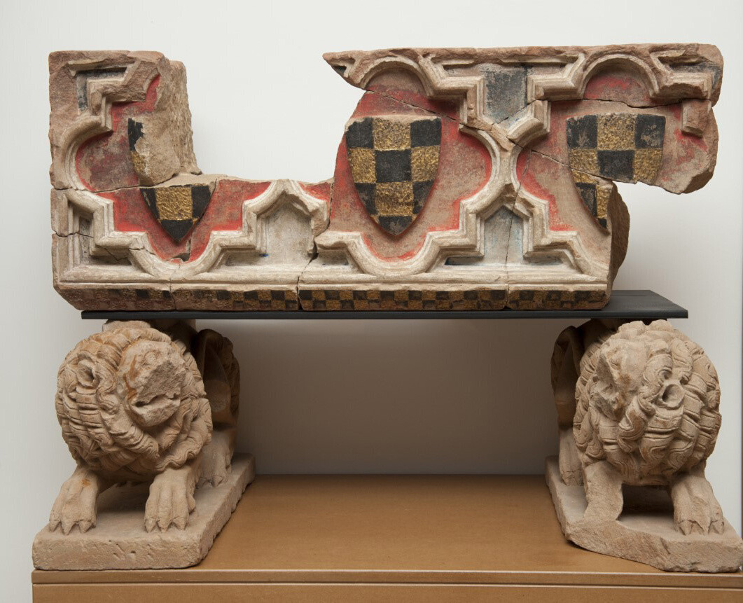 Polychrome stone sarcophagus of a small tomb with shields depicting the checkered coat of arms of the counts of Urgell. The empty sarcophagus is supported by two lions.
