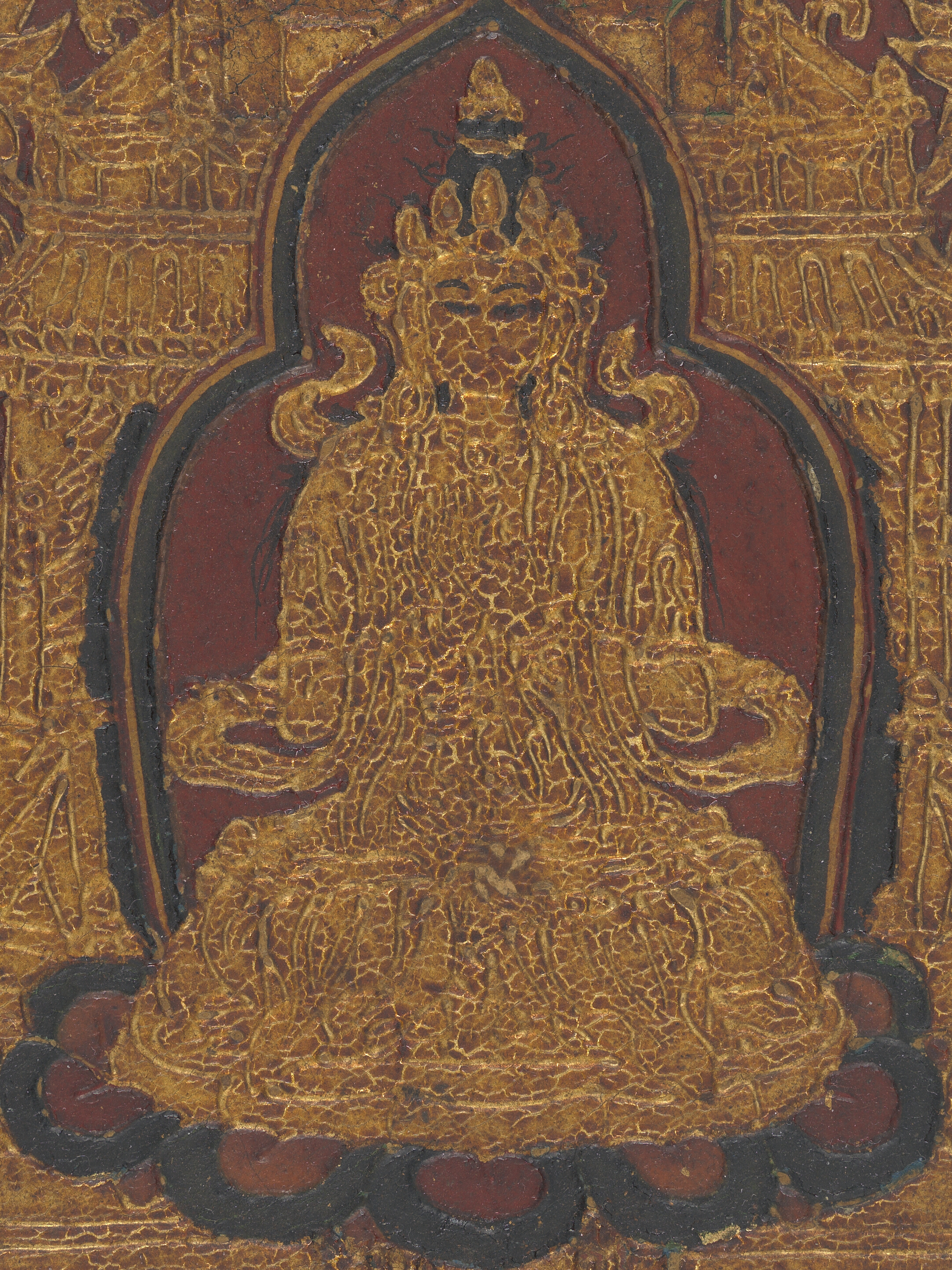 Torana-shaped panel with gilded raised decoration depicting a seated figure with some outlines in black and a red background.