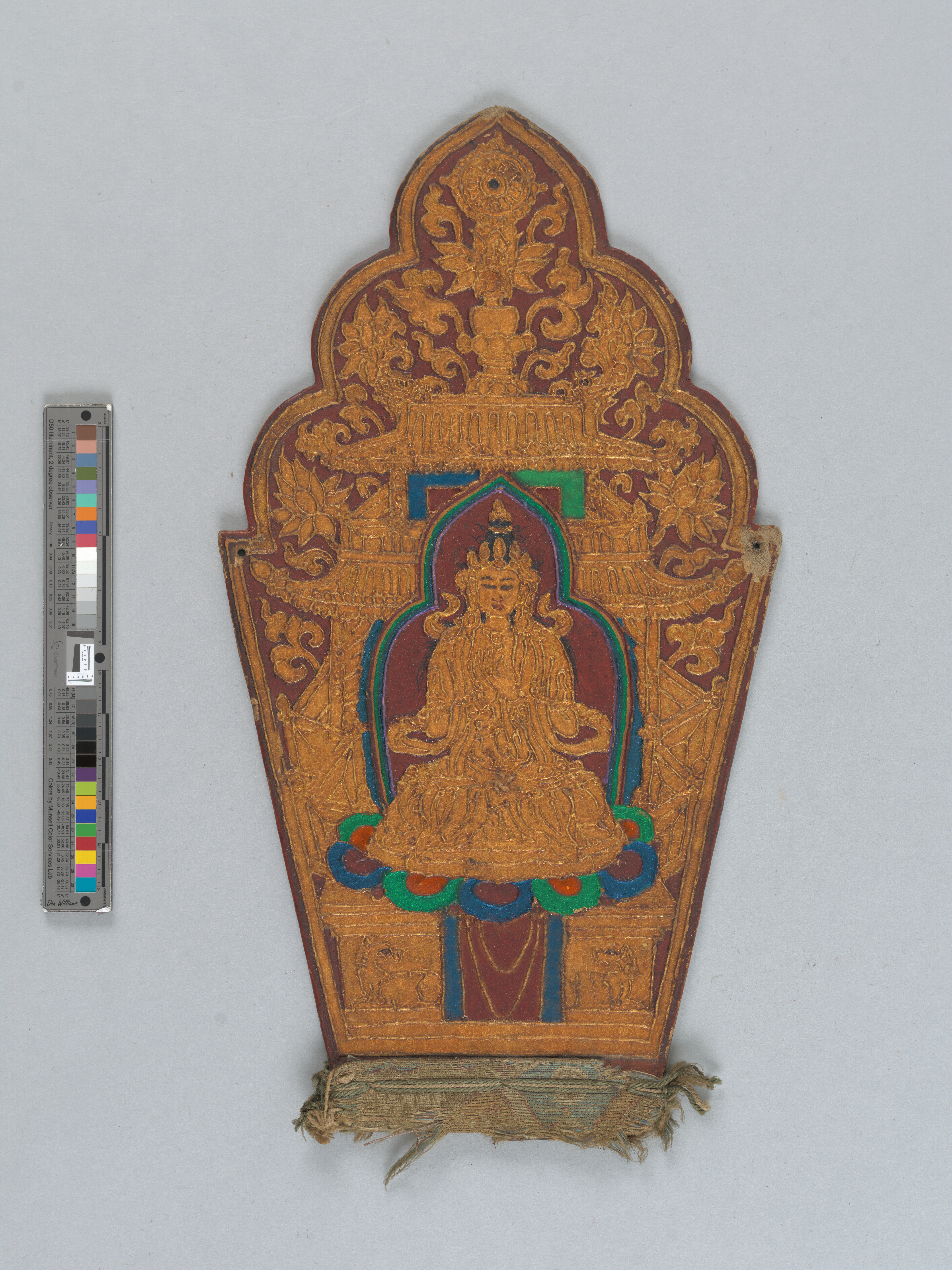 Gilded torana-shaped panel depicting a seated figure with red background and details in blue, green, orange, red, and purple.